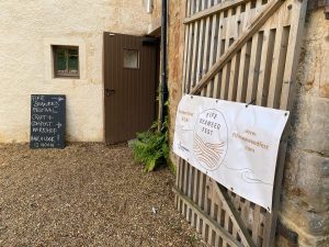 A banner for Fife Seaweed Fest is attached to a wooden gate. A chalkboard sign nearby advertises a craft and compost workshop at 12 midday.
